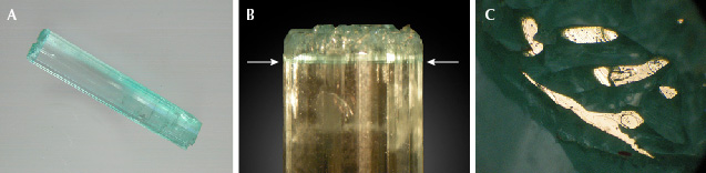 Figure 15. A: Sample 15 (37.4 mm in length), an emerald crystal with color zoning; at one end, the sample reveals a continuous rim surrounding growth areas ending in small basal faces. B: Growth and color zoning (arrows) of the crystal along the <em>c</em>-axis. C: Areas of the rim and small columns inside the rim with planes parallel to the basal pinacoid appear bright in reflected light, viewed parallel to the <em>c</em>-axis. Photos by K. Schmetzer; field of view 3.6 mm (C).