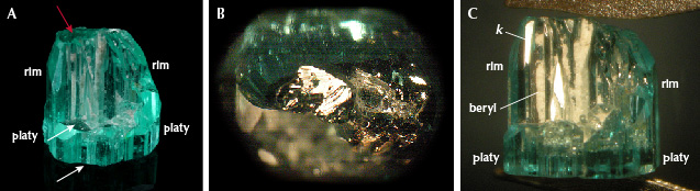 Figure 19. A: Sample 19 (7.8 mm in length), an emerald crystal in the form of a half cup developed with two parts: as a platy part with lower and upper basal pinacoid (white arrows) and an upper curved rim surrounding about half of the area of the platy part; this rim is terminated by a small basal face (red arrow). B: Stepped surface of the basal face on top of the horizontal surface of the rim. C: View of the inner surface of the circular rim on top of the platy part, in this orientation with reflective steep <em>k</em> hexagonal dipyramids, the elongated cavities are filled with fine-grained white beryl. Photos by G. Martayan (A) and K. Schmetzer (B and C); field of view 14.5 mm (B).