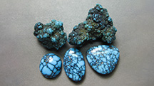 Figure 1. Extremely rare Black Web Gem mine turquoise nuggets and cabochons from Nevada. These pieces are natural with no treatments except for the backings added to the cabochons. The center oval is approximately 16 &times; 12 mm. Photo by Richard Shull; courtesy of Out of Our Mines.