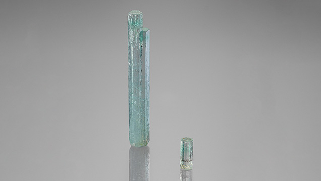 Green beryl crystals weighing 41.90 ct (left) and 4.08 ct (right) from a new source in Nigeria display concentrated color zones. Photo by Rhonda Wilson; courtesy of Rhonda Wilson (left) and Maxwell Hain (right).