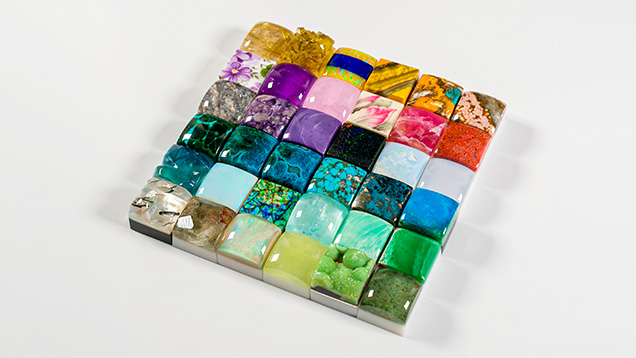 Figure 2. Various gemstone keycaps including rutilated quartz, chrysocolla malachite, amethyst, fossilized red horn coral, charoite, turquoise, opal, wavelite, and more. Courtesy of Carter Stay, Keycap Quarry.