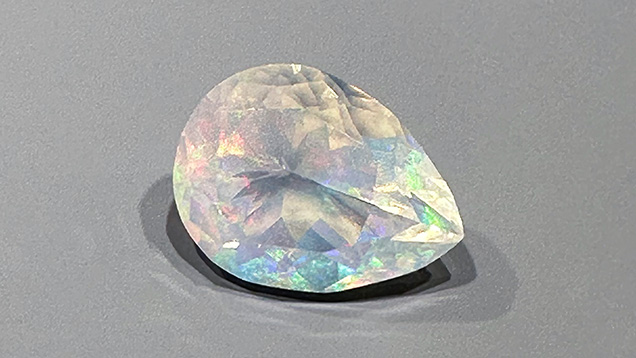 Figure 3. Highly transparent pear-shaped crystal opal from Mexico showing play-of-color. The opal measures 22.2 × 16.7 mm and weighs 17.82 ct. Photo by Jennifer Stone-Sundberg; courtesy of Columbia Gem House.