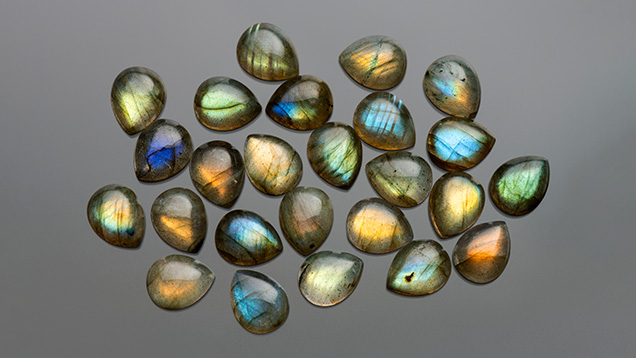 Figure 4. Colorful 8 × 10 mm teardrop labradorite cabochons. Photo by Kevin Schumacher; courtesy of Shanghai Jade Gems Factory.