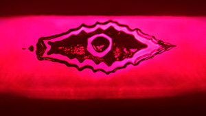 The reflection of a flux-healed fissure from a step pavilion facet in this Mong Hsu ruby resembles an evil eye. Photomicrograph by Ungkhana Atikarnsakul; field of view 1.07 mm.