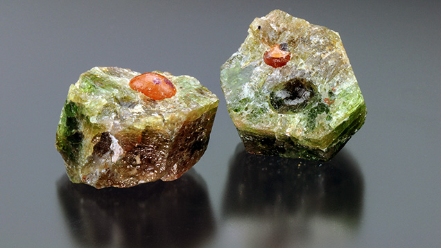 Orange spherical inclusions within the fractured fluorapatite crystal.