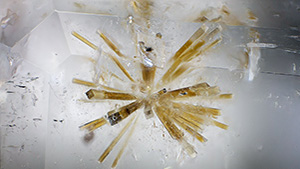 Burmese phenakite with perettiite-(Y) bundles (left) and tusionite inclusions (right).