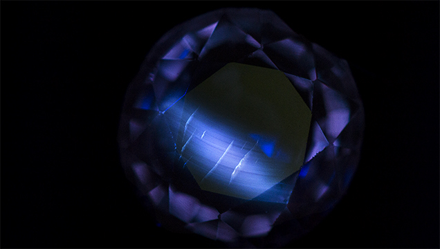 Flame-fusion synthetic sapphire displays curved banding under short-wave UV light.