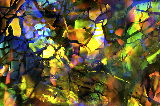 Slocum Stone opal imitation glass was manufactured by John Slocum of Michigan in the early 1970s. Thin layers of metallic film fragments suspended in the glass matrix are responsible for the interference colors observed. Field of view 5.75 mm.