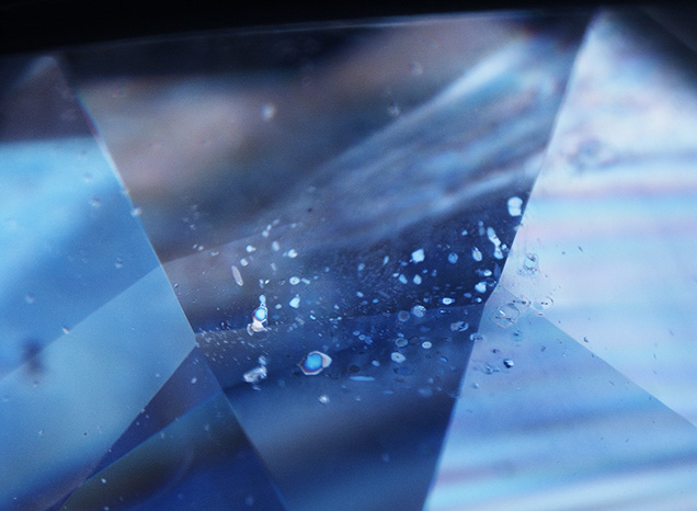 Sapphire featuring birefringent crystals in a partially healed fissure.