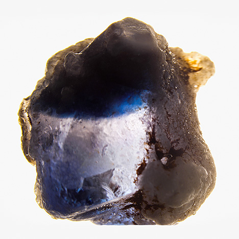 Laboratory-grown sapphire immersed in water reveals curved blue banding.