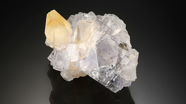 The flurorite crystals in this cluster play host to red cinnabar crystal inclusions.