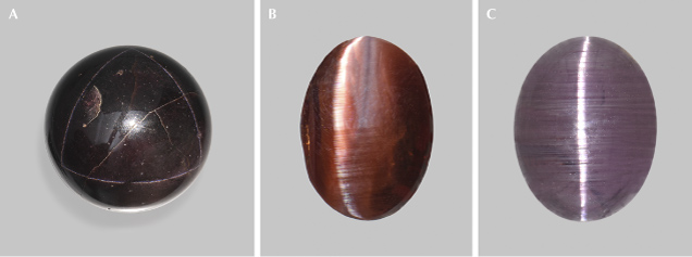 Figure 15. A: A 1,185 ct garnet sphere showing a star network of ⟨111⟩ needle inclusions (see figure 14). The star network under rotation is shown in video 2. Courtesy of GIA Museum, collection no. 4068. B: A 1.47 ct cat’s-eye almandine garnet. C: A 9.39 ct cat’s-eye spinel from Sri Lanka; courtesy of John I. Koivula. Photos by Emily Lane (A) and Annie Haynes (B and C).