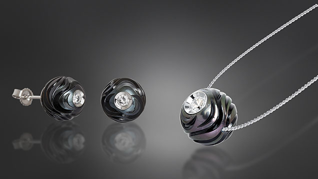 Figure 5. The Diamond in a Pearl collection, Huynh’s first, is designed to illustrate a pearl’s formation and symbolizes how true love can survive hardship. This jewelry set, named “Rhythm of Life,” features a combination of pearl carving and Diamond in a Pearl techniques. The pendant contains a 12 mm carved Tahitian pearl, and each earring contains a 10 mm carved Tahitian pearl. The whole set is mounted with 14K white gold. Courtesy of Chi Huynh.