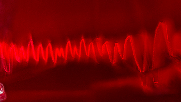 An electromagnetic wave-like pattern of whitish dust in Mong Hsu ruby. Photomicrograph by Narint Jaisanit; field of view 1.70 mm.