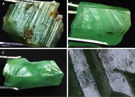 Figure 9. Microtopography of emerald crystals from Zhen’an. A: Longitudinal striation of hexagonal faces (ESC-12). B: Inclined stripes on hexagonal prism face (ESC-16). C: Angular growth steps of one of the <em>m</em> hexagonal prism faces (ESC-15). D: Hexagonal etch feature (ESC-19). Photomicrographs by Yi Guo; fields of view 14.20 mm (A and C), 11.12 mm (B), and 4.05 mm (D).