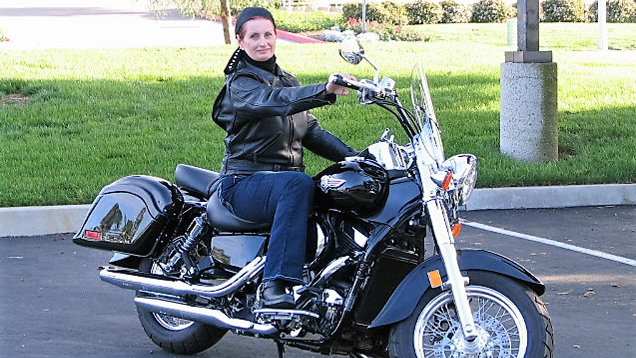 Rebecca Buys（丽贝卡·拜斯）坐在摩托车上。