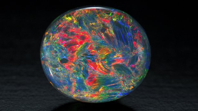 This Australian black opal oval cabochon has blue, red, yellow, orange and green colors.